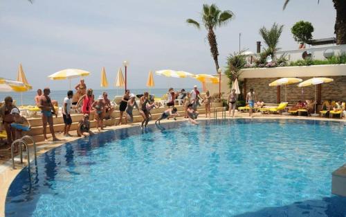 a group of people are standing around a swimming pool at Rubi Hotel in Avsallar