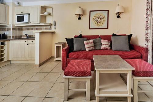 sala de estar con sofá rojo y cocina en Bastidon Golf de Pont Royal en Mallemort