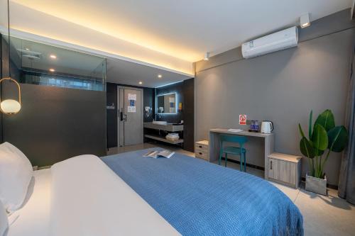 a bedroom with a large bed and a bathroom at Yangshuo EMOJI YOUTH HOSTEL in Yangshuo