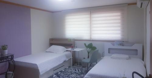 a small room with two beds and a table at Yire House in Seoul
