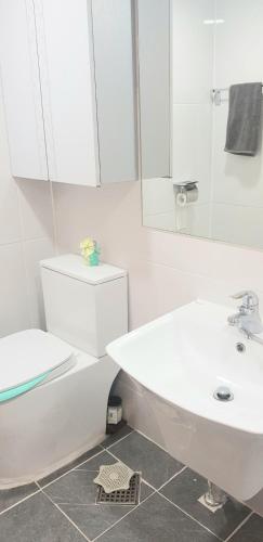 a white bathroom with a sink and a toilet at Ireh House in Seoul