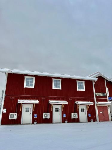 a red barn with white doors in the snow at Flygeln in Leksand