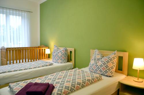 Kerkwitz的住宿－Ferienwohnung "Zum Dorfkrug"，绿墙客房中的两张单人床