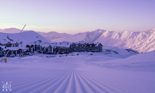a ski lodge in the snow with mountains in the background at New Gudauri Ski4Life in Gudauri