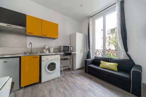 cocina con lavadora y armarios amarillos en Residence Germot - Appartements design Centre Ville proche Thermes, en Vichy