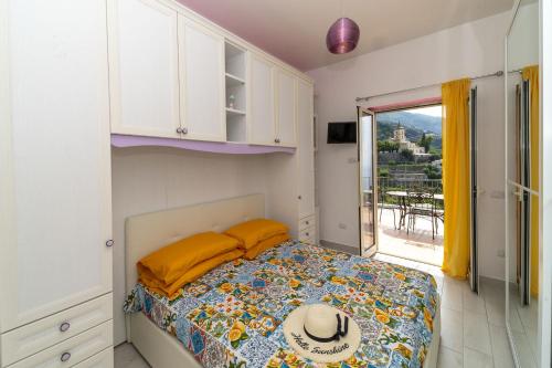 una camera da letto con un letto con un cappello sopra di Casa Melevyen in Positano a Positano