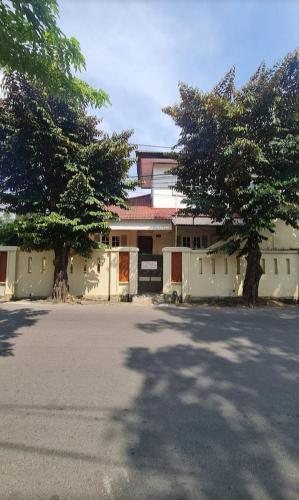 un edificio con dos árboles frente a una calle en GABS GETHOUSE en Yakarta