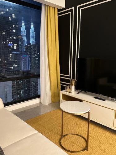 ein Wohnzimmer mit einem Großbild-TV und einem Tisch in der Unterkunft Axon Residence By Leo Suites in Kuala Lumpur