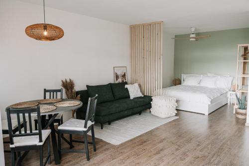 Kleine Seezeit في برباش ام نيوسيدله: غرفة معيشة مع أريكة خضراء وطاولة