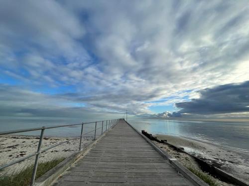 a wooden boardwalk leading to the beach under a cloudy sky at Rosehaven on Rosebud in Rosebud