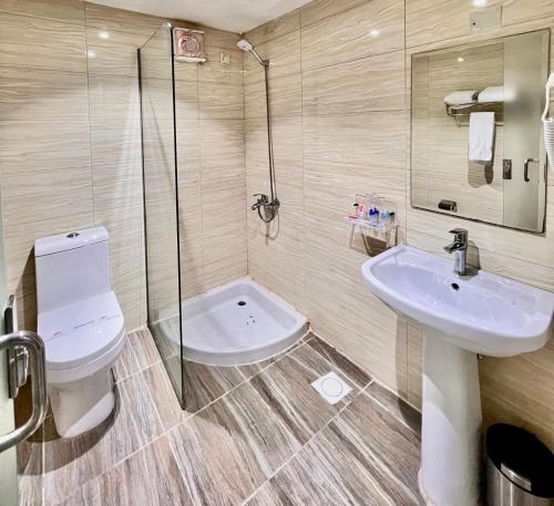 a bathroom with a toilet and a sink and a shower at Al Muhaidb Residence Al Maidan in Hafr Al-Batin