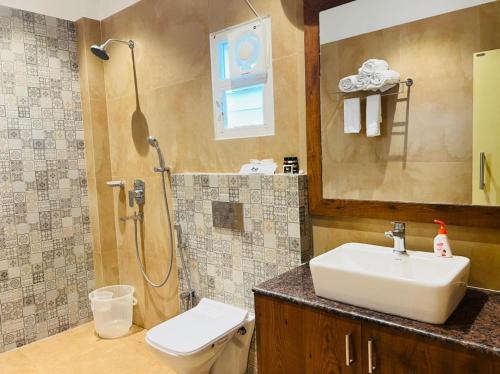 La salle de bains est pourvue d'un lavabo, de toilettes et d'une douche. dans l'établissement OXYTEL CLUB & RESORTS PVT. LTD., à Chālsa Mahābāri