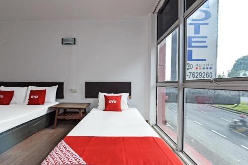 um quarto com duas camas e uma janela em OYO 90892 L&E Hotel em Seremban