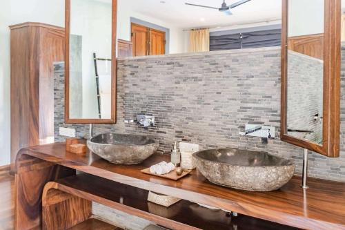 two sinks on a wooden counter in a bathroom at Eraeliya Villas & Gardens in Weligama