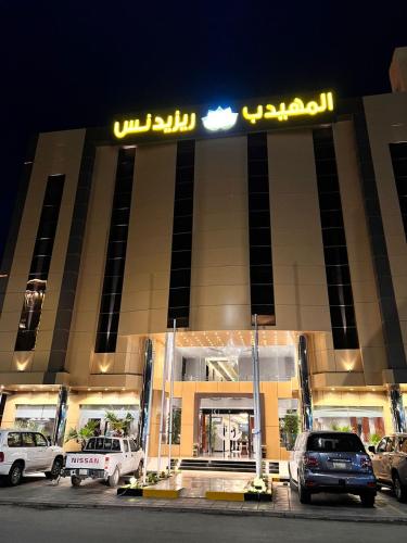 a building with cars parked in front of it at night at Al Muhaidb Residence Al Maidan in Hafr Al Baten