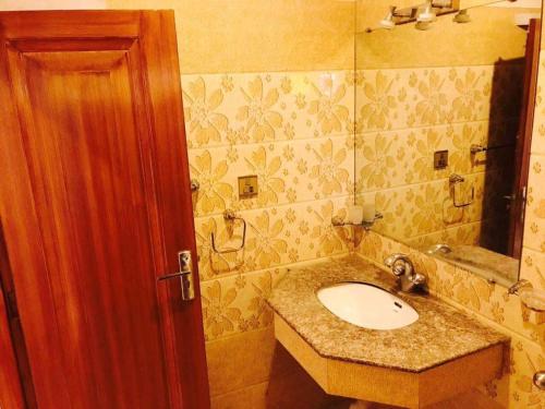 a bathroom with a sink and a mirror at PAK HOTEL Islamabad in Islamabad