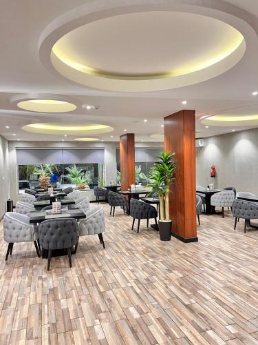 a lobby with tables and chairs in a building at Al Muhaidb Residence Al Maidan in Hafr Al Baten