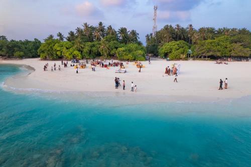 a group of people standing on a beach at Hudhuveli Kamadhoo in Milaidhoo
