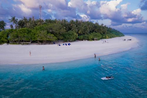 an island in the ocean with people on a beach at Hudhuveli Kamadhoo in Milaidhoo