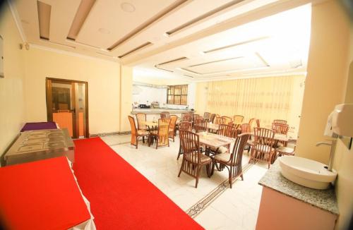 Habitación con comedor con mesas y sillas. en Gold Suite Hotel en Nakuru