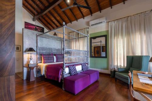a bedroom with a bed with a metal canopy at Eraeliya Villas & Gardens in Weligama