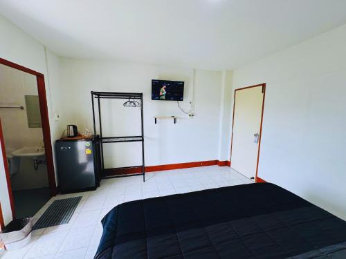 a room with a bed and a tv on the wall at K.L.Apartment in Chalong