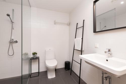 a white bathroom with a sink and a toilet at Orange Sipelga Balcony & Free Parking in Tallinn