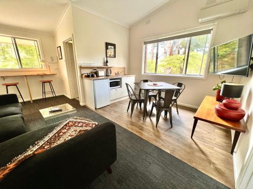 sala de estar con sofá y mesa en The Warby, where mid-century style meets the mountains, en Warburton