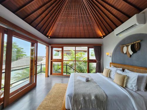 une chambre avec un grand lit et de grandes fenêtres dans l'établissement villa 2 kamar di canggu kawaii villa, à Denpasar