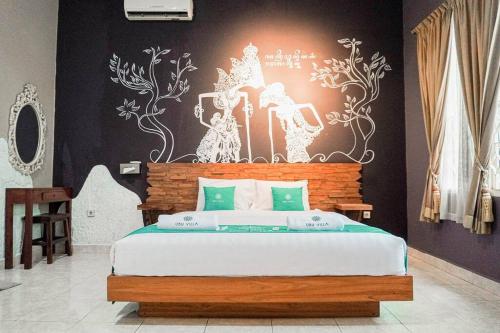 - une chambre avec un lit orné d'une peinture murale dans l'établissement Tamu Ibu by Ubu Villa - 5 Bedrooms Villa in Yogyakarta, à Beran-kidul