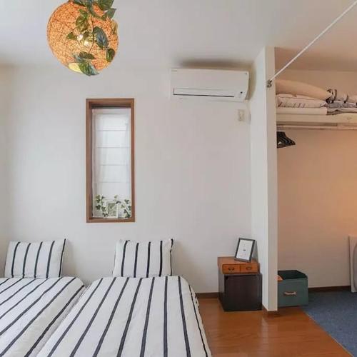 a room with two beds and a window at 直达-池袋-2分钟 车站徒步6分钟 3bedrooms-IT0338 in Tokyo