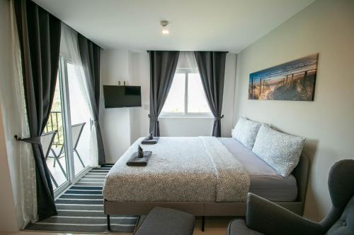 ein Hotelzimmer mit einem Bett und einem Balkon in der Unterkunft Mantra Beach Condominium Suite 2 - Mae Phim in Ban Tha Fat