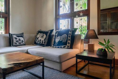 a living room with a couch with blue and white pillows at Eraeliya Villas & Gardens in Weligama