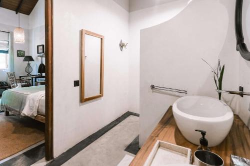 a bathroom with a sink and a mirror at Eraeliya Villas & Gardens in Weligama