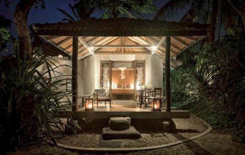 a house with a table and chairs and lights at Eraeliya Villas & Gardens in Weligama
