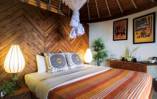 a bedroom with a large bed with a wooden wall at Eraeliya Villas & Gardens in Weligama
