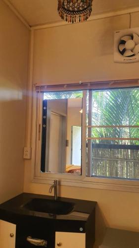 a bathroom with a sink and a mirror at บ้านสวนในฝัน-ตลาดน้ำท่าคา in Samut Songkhram