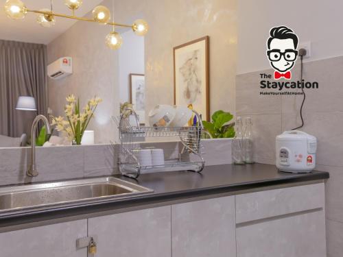 Staycation Homestay 31 Skyvilla Condominium near MJC في كوتشينغ: مطبخ مع حوض وطاولة عمل
