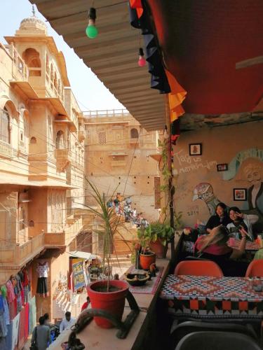 a room with people sitting in chairs in a building at Marigold Home Stay in Jaisalmer