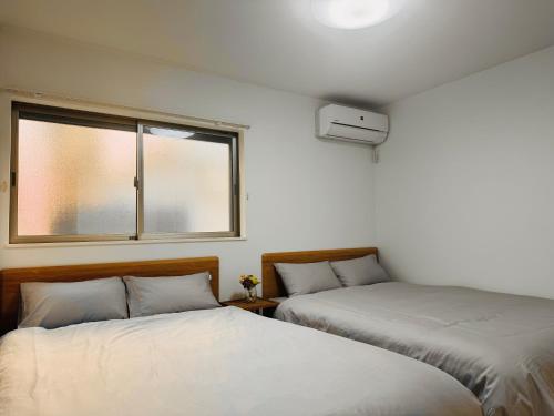 Duas camas num quarto com uma janela em MISTEL em Tóquio