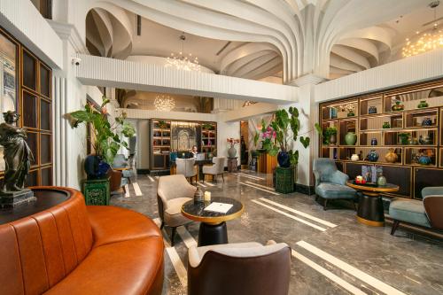 a lobby with chairs and tables in a building at MAY DE VILLE Lakeside Hotel in Hanoi