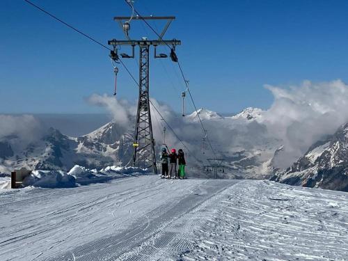 three people standing on a ski lift in the snow at Ferienwohnung Haus am Bach in Toggenburg in Wildhaus