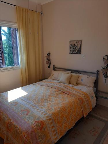 a bedroom with a large bed with a window at Limnaria Deluxe Maisonette in Nea Paphos