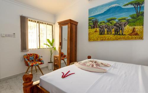a bedroom with a bed and a painting on the wall at Shivo Guest House in Kiembi Samaki
