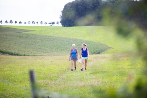 two women walking in a field of grass at B&B Brakke Berg in Berg en Terblijt
