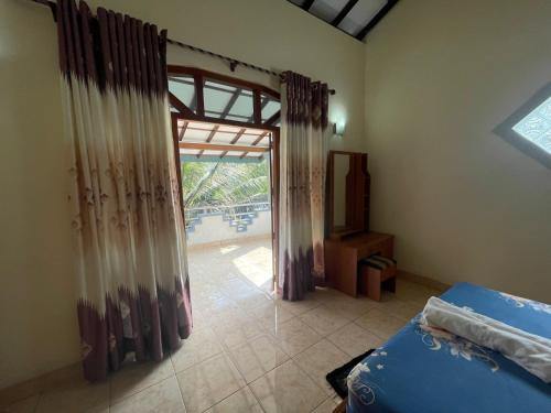 um quarto com uma cama e uma porta de vidro deslizante em Pasidu Villa em Kalutara