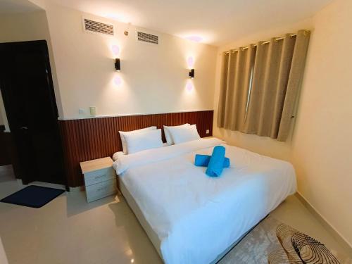 a bedroom with a white bed with a blue bow on it at Spacious Studio apartment in the Heart of JLT in Dubai