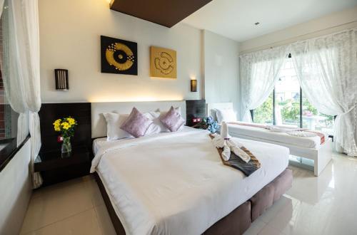 a bedroom with a large bed and a large window at Blue Carina Hotel Phuket in Phuket Town