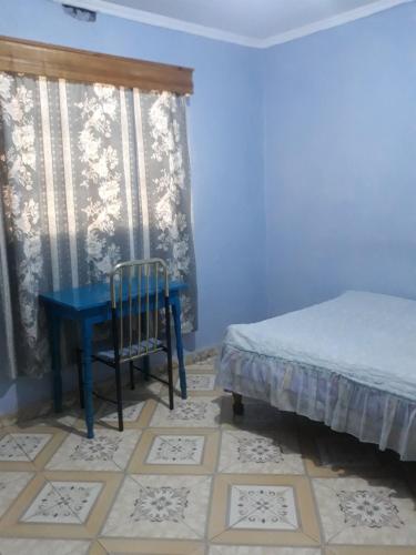 Habitación azul con mesa azul y silla en RockVilla GuestHouse Njabini SouthKinangop Nyandarua, en South Kinangop