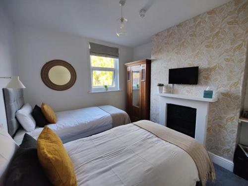 - une chambre d'hôtel avec 2 lits et une cheminée dans l'établissement The Wincheap B&B, à Canterbury